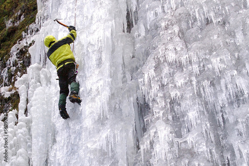 Ice climber on frozen waterfall