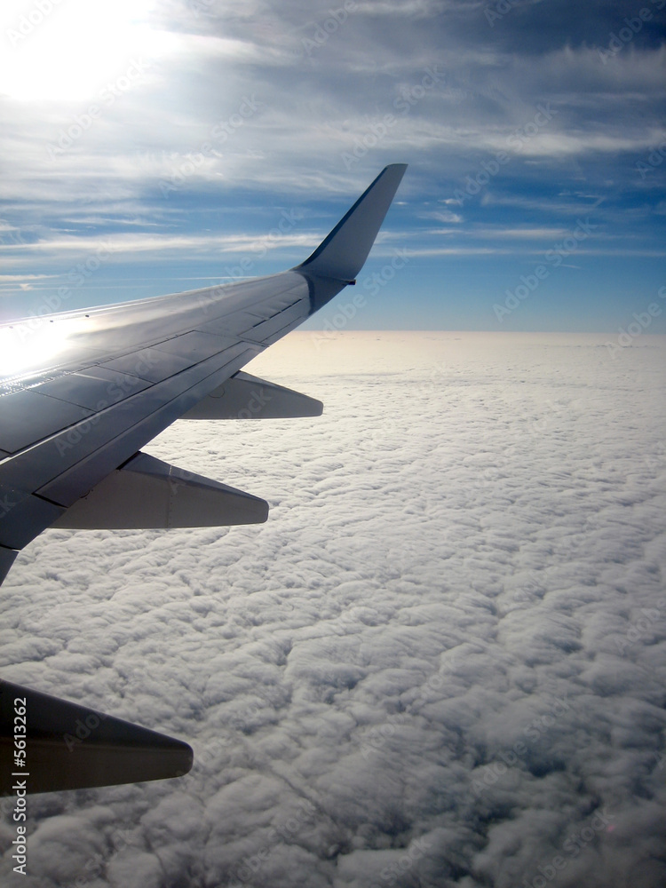 Obraz premium View from aircraft window showing wing and clouds below