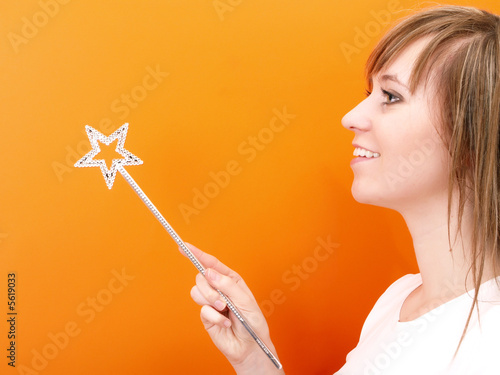 Beutiful and happy fairy with wand in the hand.