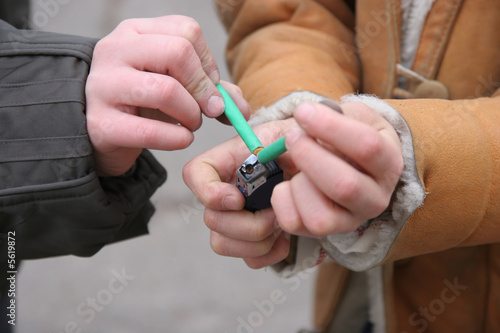 two boys handle petard with lighter