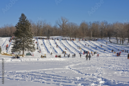 Urban winter scene, with people sliding on a slope.