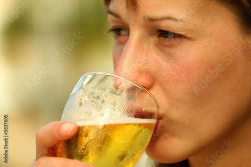 Frau trinkt glass bier im Freibad photo