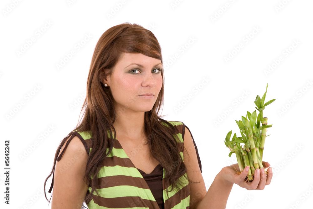 Pretty brunette holding young bamboo plants in her hands Pretty brunette holding young bamboo plants in her hands