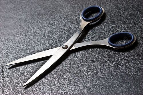 Photo of blue scissors on texture imitation leather