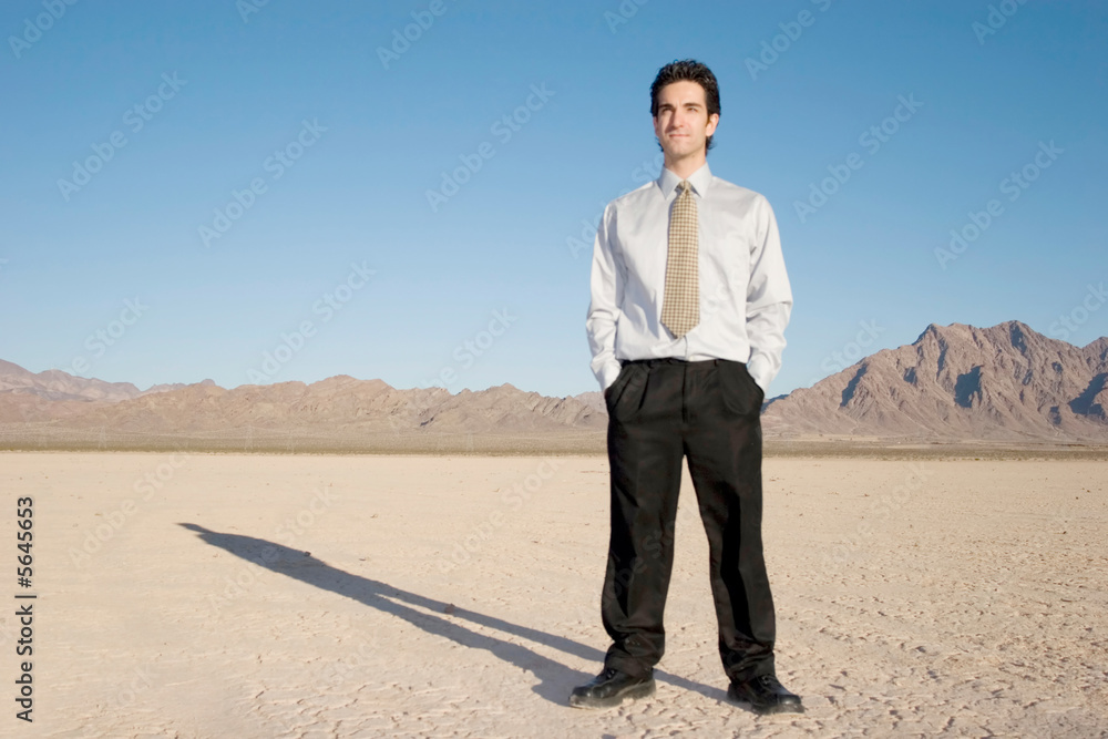 Young businessman standing in the desert Young businessman standing in the desert