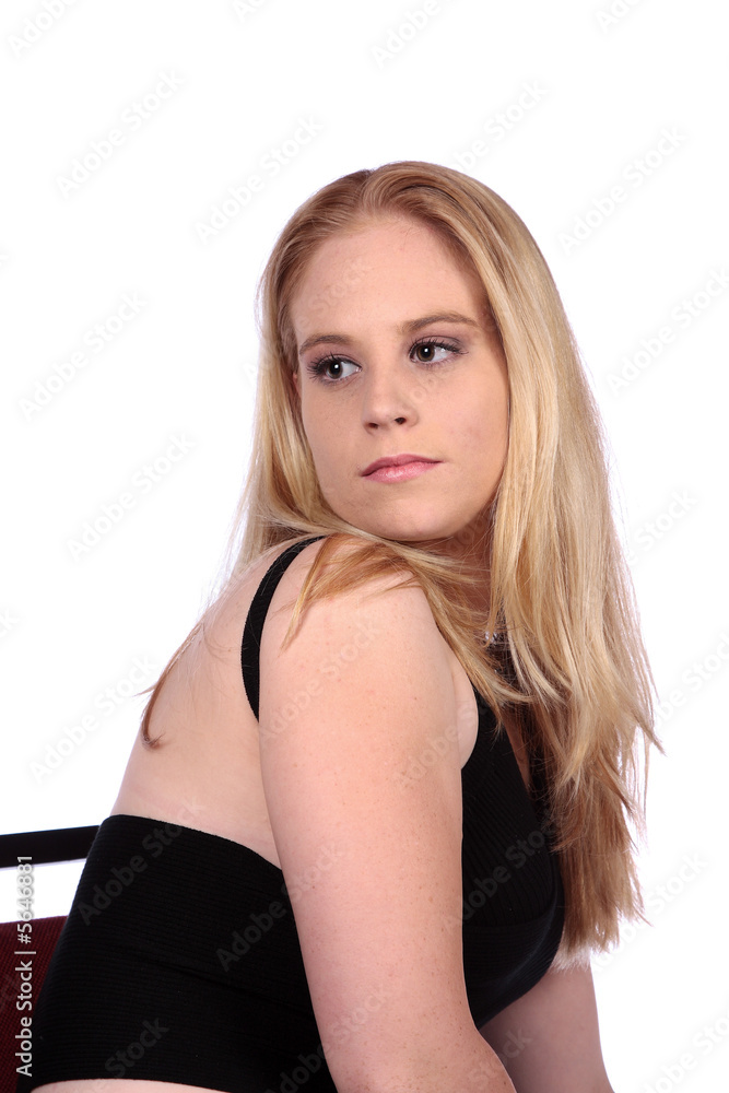 Young female model sitting on chair looking back Young female model sitting on chair looking back
