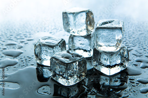 Melting ice cubes on reflective background