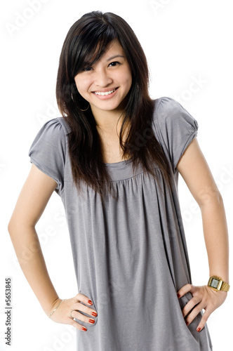 A cute young Asian woman in grey dress on white background