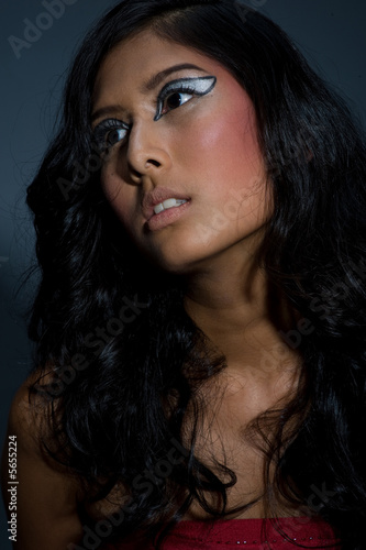 A beautiful young Asian woman with long hair on grey background