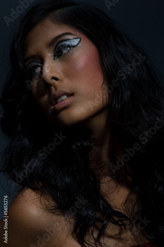 A beautiful young Asian woman with long hair on grey background