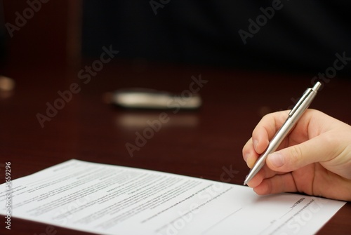 Hand with a pen about to sign a contract