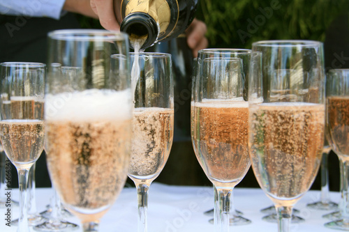Pouring Champagne into wine glasses