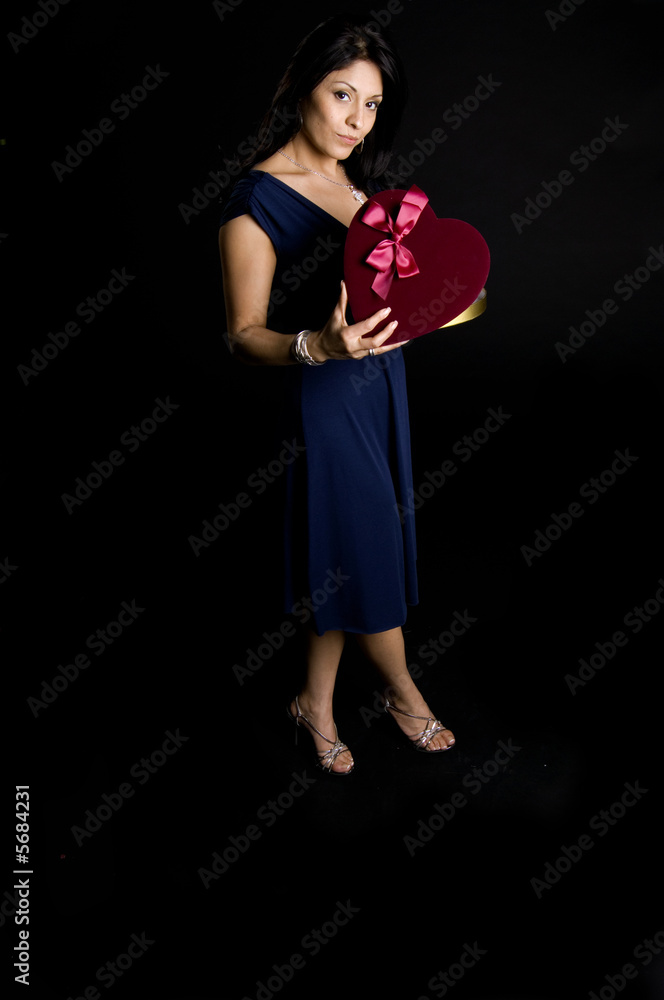 Beautiful model holding red heart with smile on face