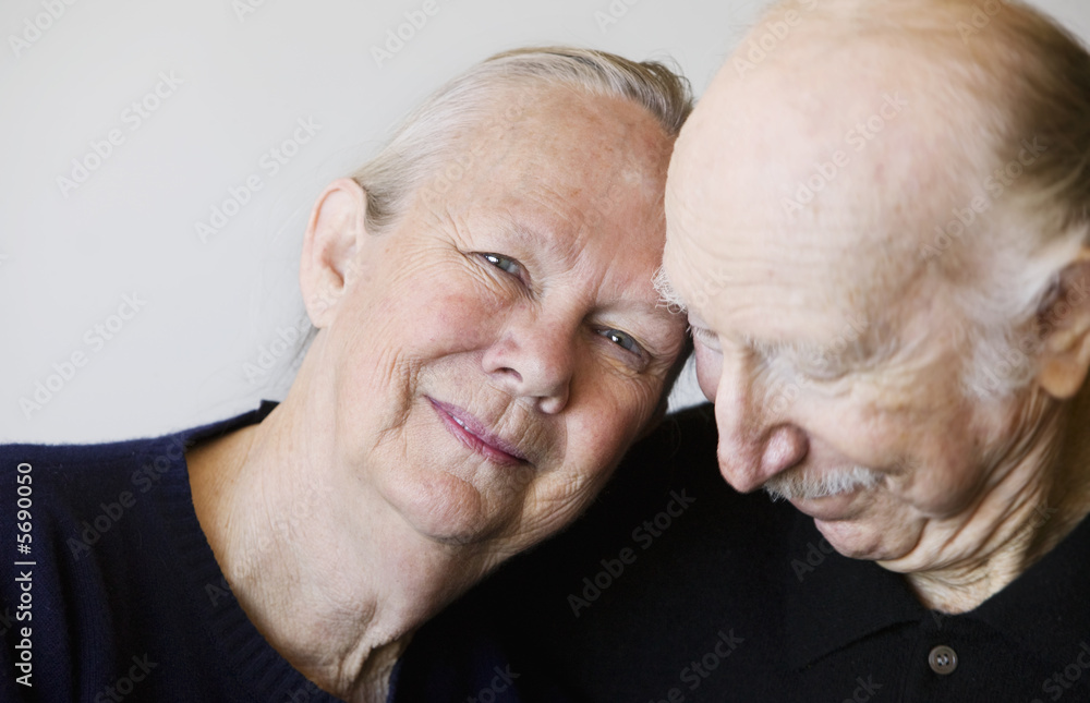 Close-up of senior couple embracing focuses on smiling woman Close-up of senior couple embracing focuses on smiling woman