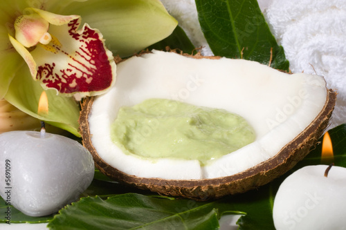 Avocadococonut scrub in coconut shell, orchid flower candles. 