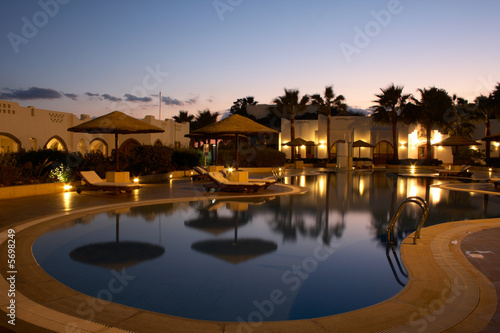 swimming pool with evening illumination in tropical resort