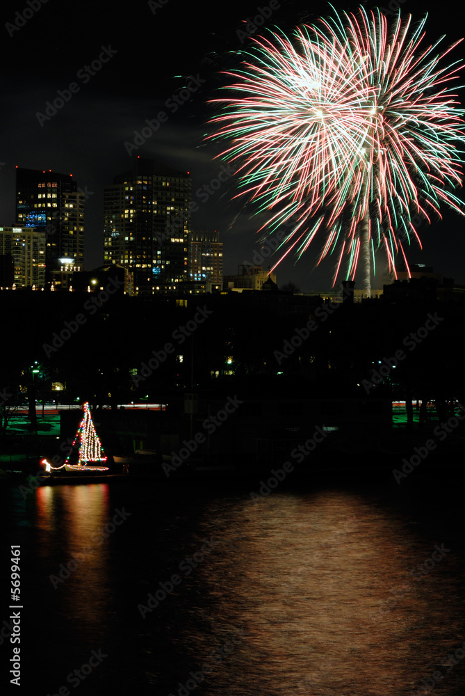 Fireworks over Boston. Colorful sailboat on Charles River.