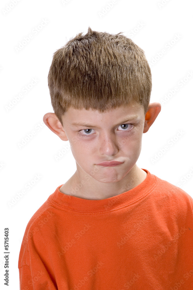 Young boy wearing an orange sweatshirt looking angry. Young boy wearing an orange sweatshirt looking angry.