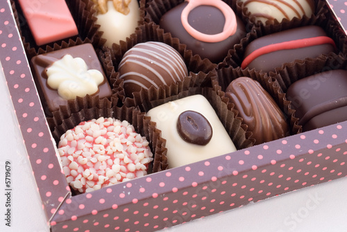 Part of box with chocolate bonbons on white background