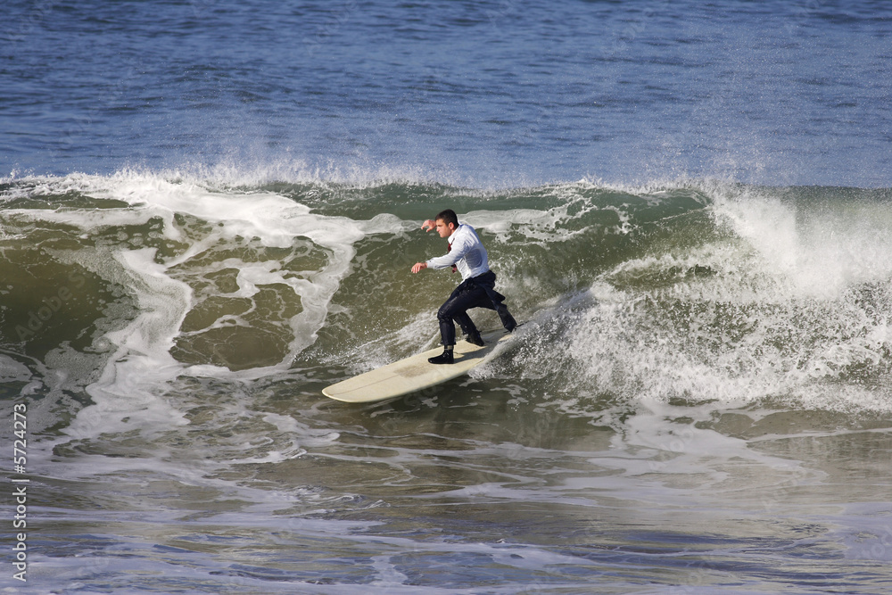 homme en smoking entrain de surfer une vague homme en smoking entrain de surfer une vague