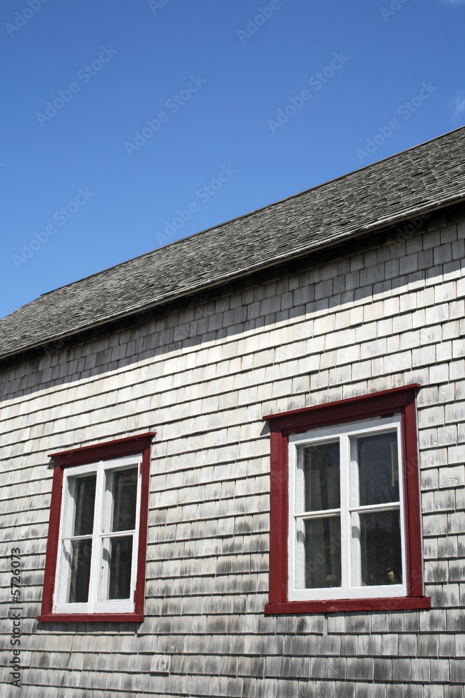 Windows and roof of an old rustic house.