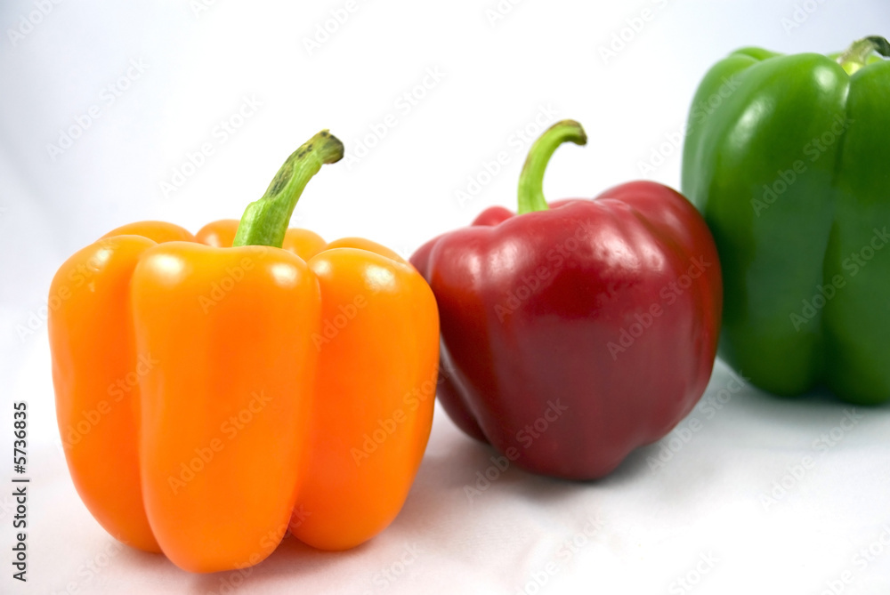orange red green peppers on a white background orange red green peppers on a white background