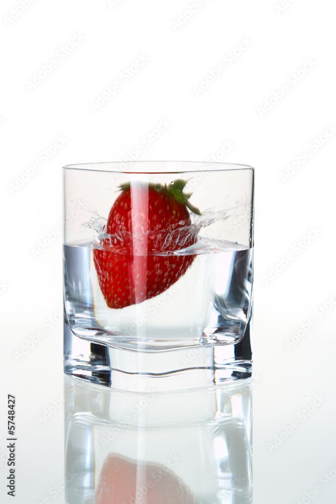 strawberry falling in waterglass