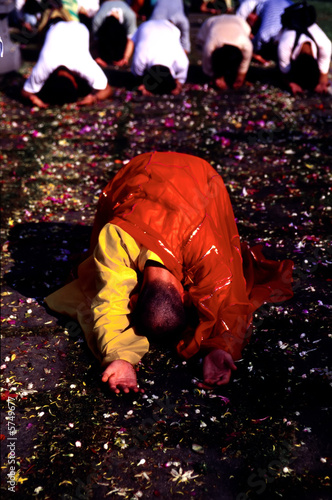 Monk bowing with followers doing the same in the background..
