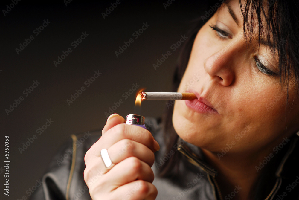 Fototapeta premium A dark hair woman lighting up her cigarette