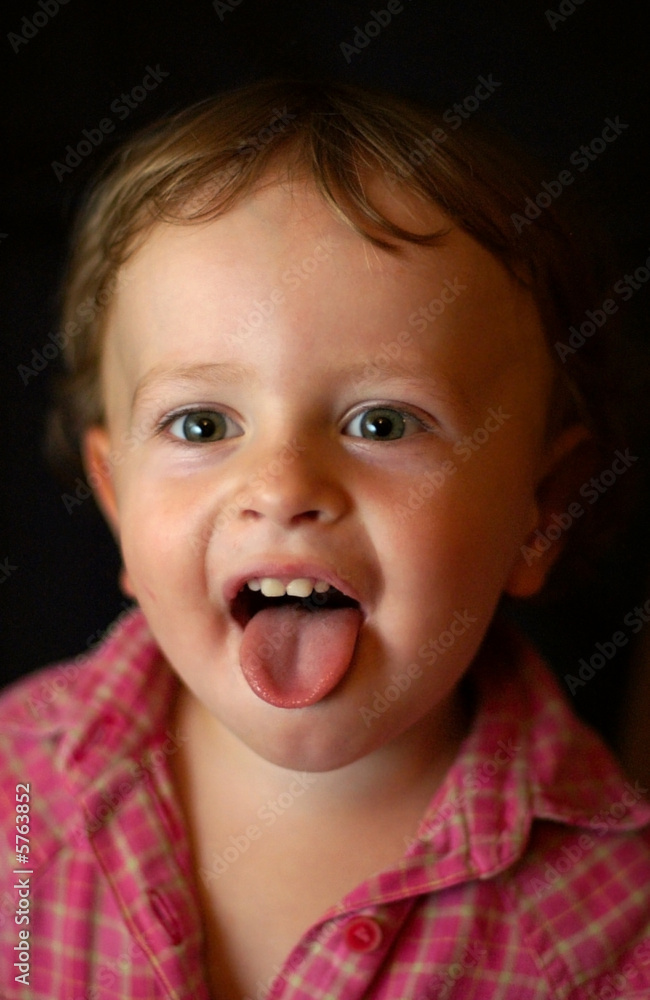 A boy grimacing showing tongue