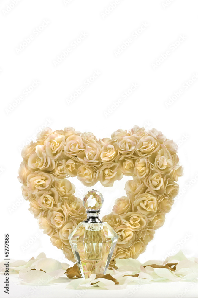 Heart of roses with crystal bottle and petals