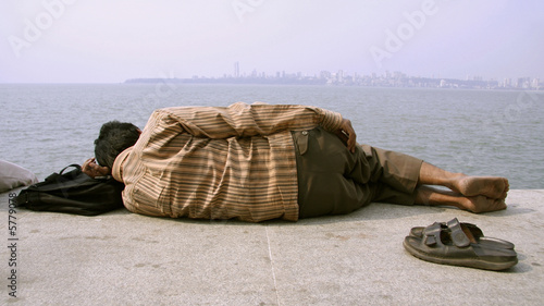 man catching a nap on sidewalk, mumbai, india