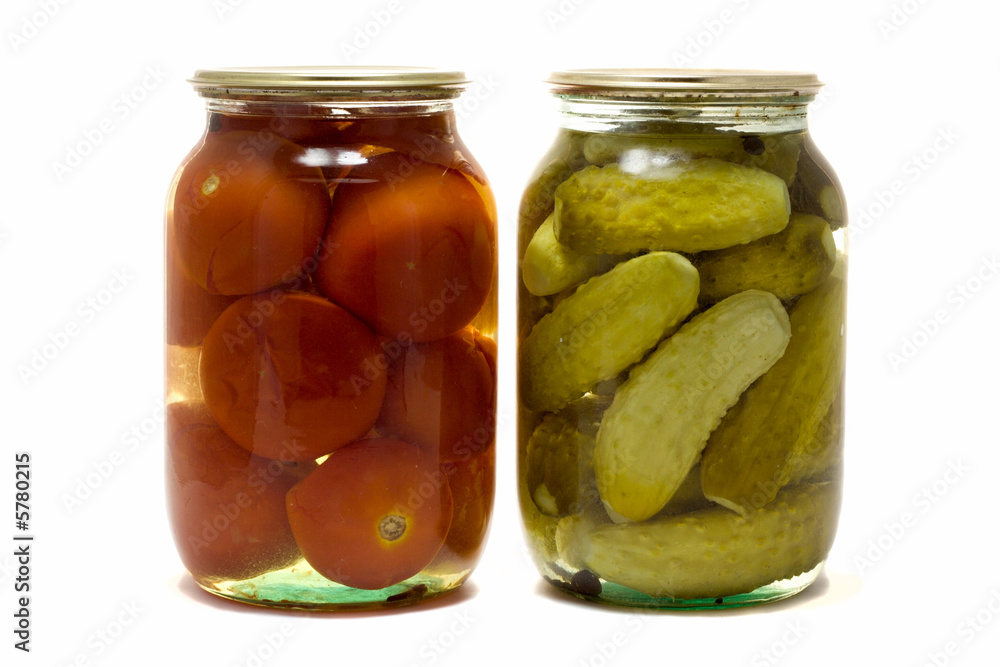 two glass jars with preserved tomatoes and cucumbers two glass jars with preserved tomatoes and cucumbers