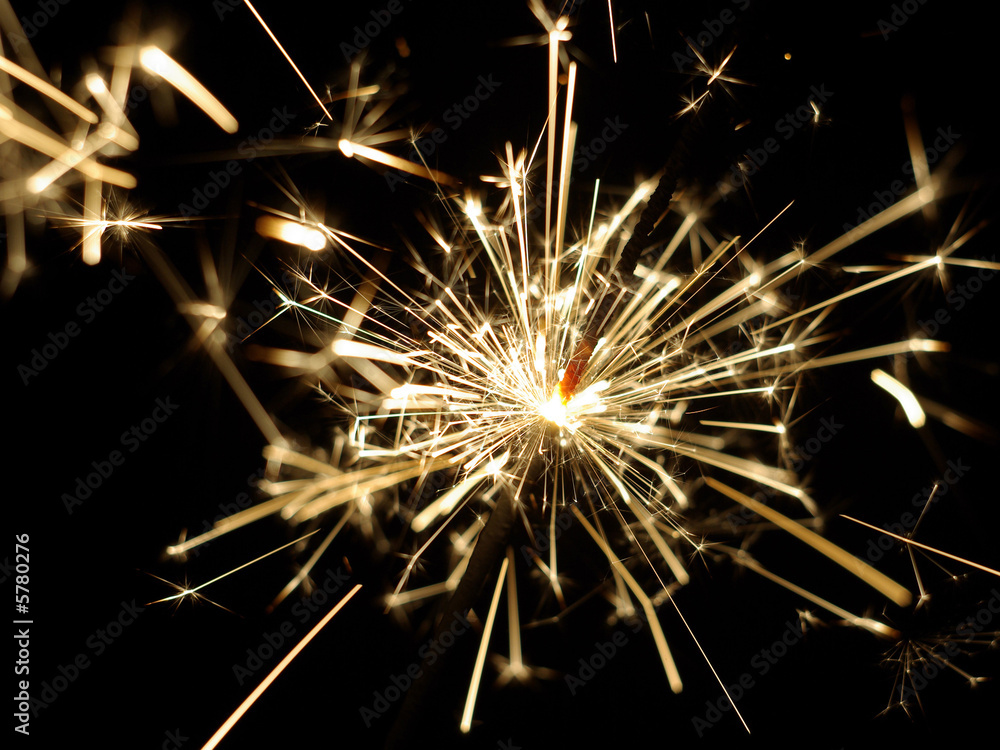 A lit sparkler showing bright sparks