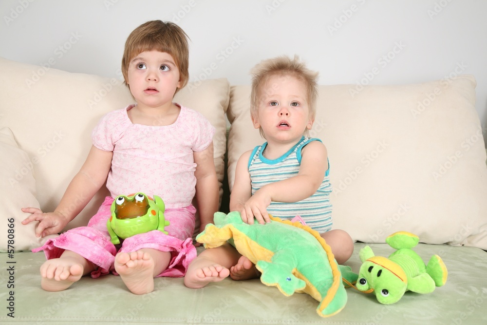 two children on sofa with toys two children on sofa with toys