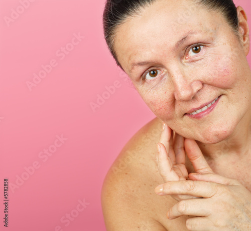 Older woman of great natural woman on a pink background 