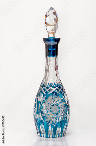 Ancient cristal decanter with reflection over white background