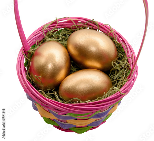 Colorful Easter basket containing 3 golden eggs.