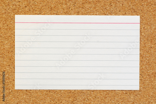 lined index card on cork board background photo