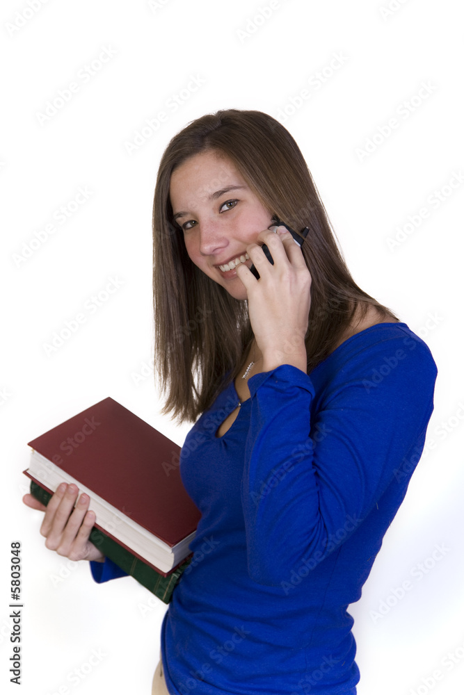 College student talks on her cellphone while holding books College student talks on her cellphone while holding books