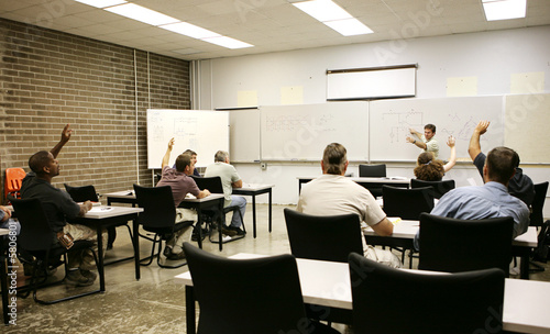 Adult education class raising their hands