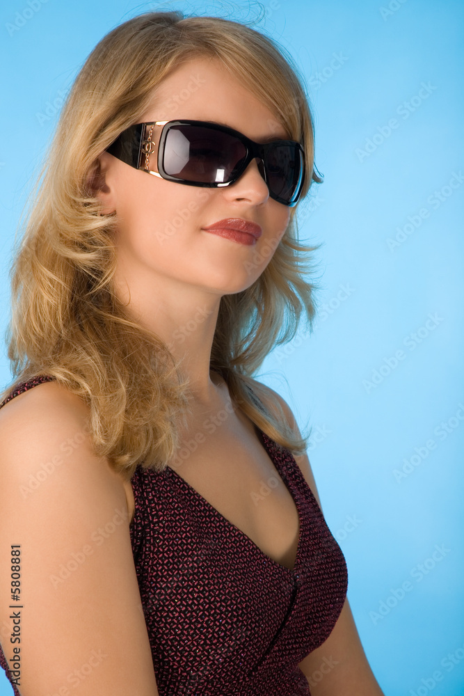 Naklejka premium portrait of young blond woman on blue background