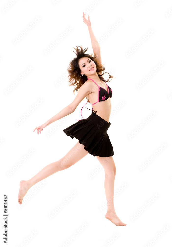 young woman in bkini top & skirt jumping freely and happily