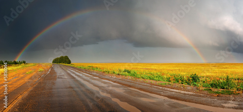Landscape with country road and rainbow photo
