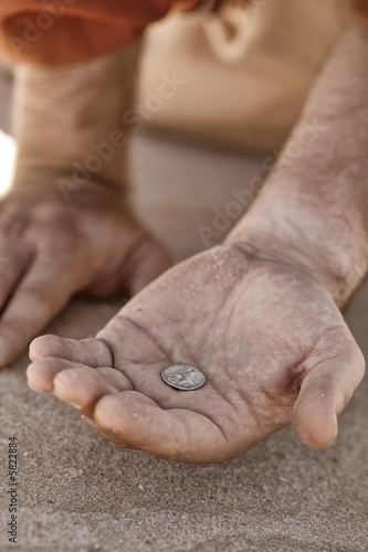 Hand holding a single coin - beggar, poverty, charity, 