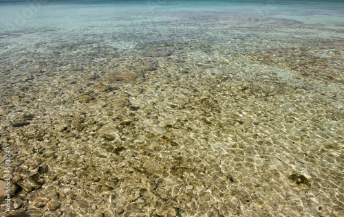 pebbles in the shallow clear tropical water as a background
