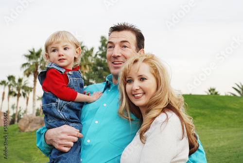happy couple with a child smiling and enjoying their time