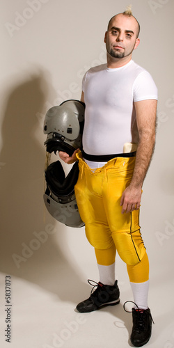 An American football player. Standing holding shoulderpads. photo