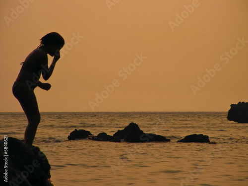 Summer time silhouette of child before jumping to sea