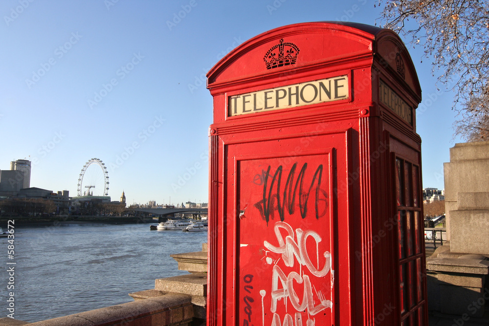 London: telephone box with graffiti along the Thames